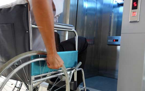 Persona in carrozzina che entra in un ascensore